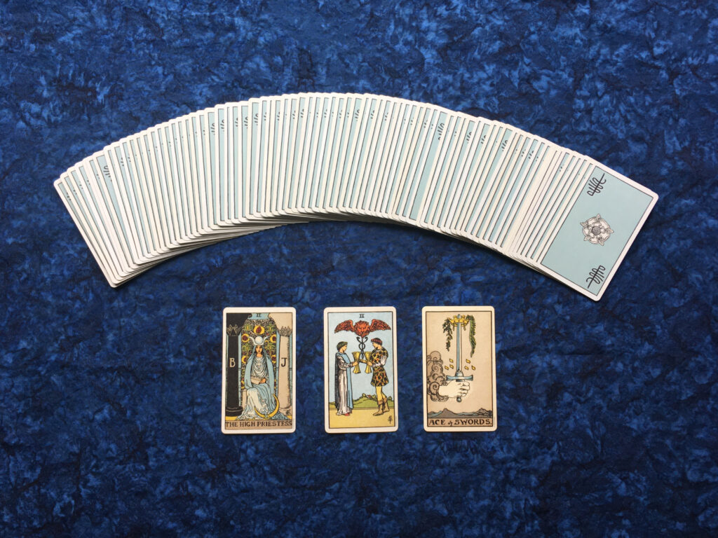 Plusieurs cartes de tarot disposées sur une table, illustrant les arcanes mineurs